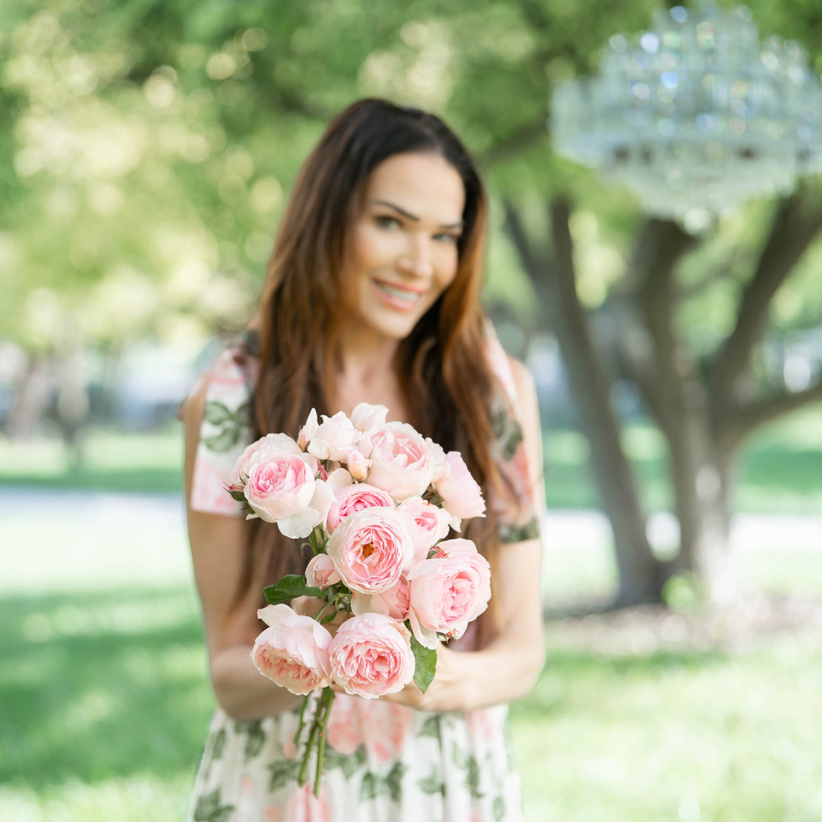 Woman holding pink flowers in a park