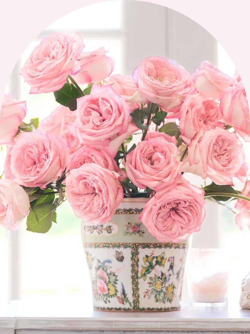 A bouquet of pink garden roses in a painted vase